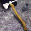 A tomahawk hatchet with a wooden handle, leaning against a small black box on the floor.