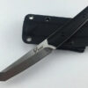 A fixed blade tactical Tanto Knife resting against its sheath.