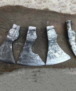 Four axe heads laying on the ground.