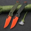 Two folding camping pocket knives with orange colored blades, resting against green color paracord rope.