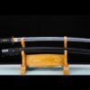 A Japanese Samurai Katana and its black scabbard diplayed on a wooden stand.