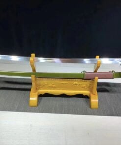 A one handed cavalry saber sword and its army green scabbard displayed on a wooden stand.