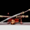 A Chinese Dao sword displayed next to its decorative scabbard, on a small wooden sword stand.