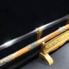 A Chinese straight sword Jian, displayed next to its decorative scabbard, on a small wooden sword-stand.