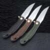 Three folding bushcraft knives with different color handles and blades opened.