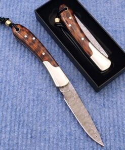 Two gentlemans pocket knives; one with blade opened lying on blue carpet, and the other in a closed position within a small black box.