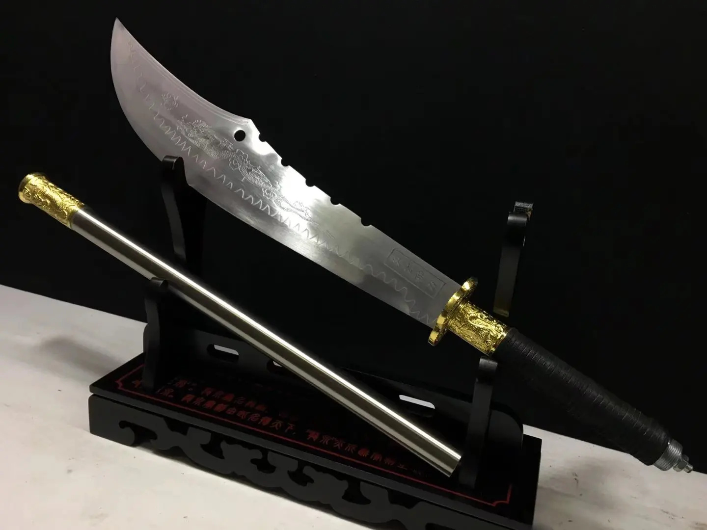 Guan Dao A Guan Dao weapon displayed next to its pole handle extension, on a wooden stand.