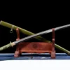 A type 98 Shin Gunto sword Katana, displayed crossed against its army green scabbard, leaning against a small wooden stand.
