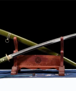 A type 98 Shin Gunto sword Katana, displayed crossed against its army green scabbard, leaning against a small wooden stand.