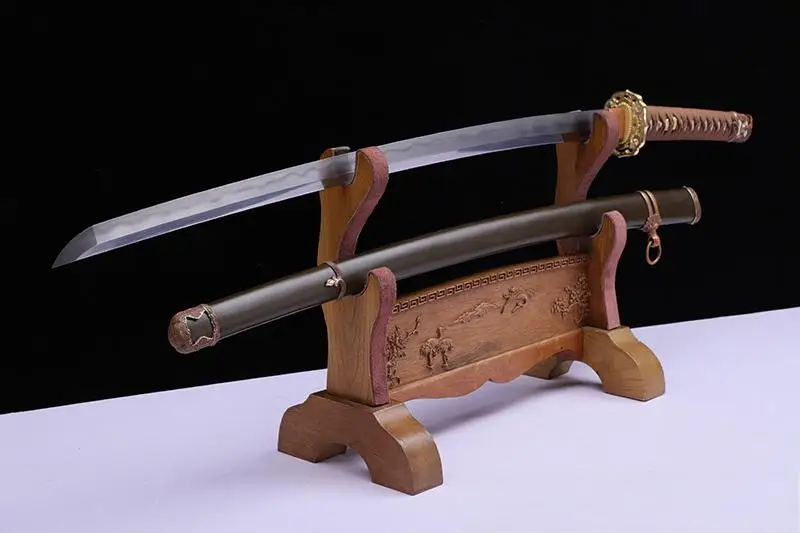 Military Sword A WW2 military sword Katana displayed on a small wooden stand, next to its army green scabbard.