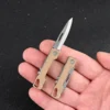 A man's hand holding a mini edc knife.