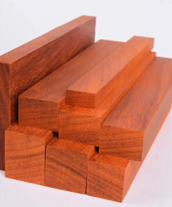 Multiple blocks of African Padauk wood stacked.