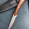 A small game processing knife lying against its sheath.