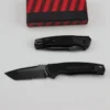 Two folding self defense folding knives; one with blade opened and the other in a fully closed position next to a small box.