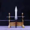 A spear sword weapon, displayed next to its two pole handle extensions, leaning against a small wooden stand.