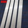 Four pieces of long stainless steel material lying on blie material, with red colored 440C written in the top left hand corner.