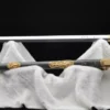 A Chinese Jian, straight sword displayed nect to its decorative scabbard, upon a white cloth sheet.