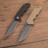 Two survival folding knives layed side-by-side on a wooden floor.