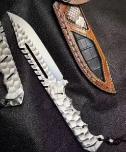 A fixed blade tactical bowie knife, displayed next to its leather sheath.