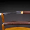 A Japanese Tanto Shirasaya knife displayed next to its sheath, on a wooden stand.