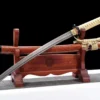 A Japanese Wakizashi short sword and its scabbard displayed on a wood stand.