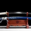 A Japanese Wakizashi sword and its scabbard displayed on a wooden stand.