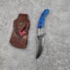 A folding Damascus blue pocket knife with leather pouch.