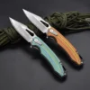 Two color pocket knives lying against paracord rope.