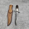 A Damascus bowie blade deer antler knife with leather sheath.