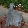 Five pieces of tool grade steel resting against bricks and garden edging.