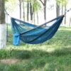 Backpacking travel hammock erected among forest trees.