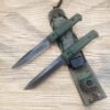 Two army issue knives lying on a knife sheath.