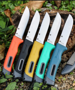 Five fixed blade bushcraft knives lying on forest floor.