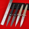 Four folding dagger defense knives next to a measurement ruler.