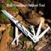 A folding multi purpose pocket knife with tool opened, lying on forest floor.