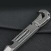 A mini crowbar multi size wrench multi tool resting against black material.