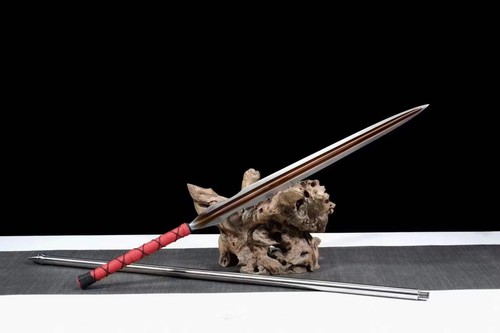 Long Bladed Spear A long bladed spear sword displayed leaning against a wood log, with its pole handle extension on the floor below.