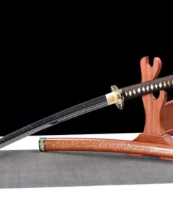 A Japanese Wakizashi sword leaning against a wooden stand, with its scabbard below on the floor.