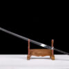 A Miao Dao Chinese Longsword displayed leaning against a small wooden sword-stand.
