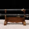 A Chinese straight sword Jian, displayed next to its decorative scabbard, on a small wooden stand.