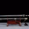 A decorated dragon handle sword Jian, displayed next to its scabbard, on a small wooden sword-stand.