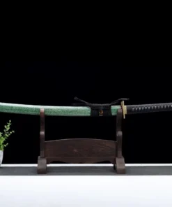 A long Nagamaki sword sheathed within its green scabbard, displayed on a wooden stand.