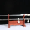 A straight, single edged sword and its scabbard displayed on a wooden stand.