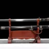 A single handed sword with a single edged blade displayed with its scabbard on a wooden stand.