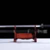 A fire brid sword Jian, displayed next to its decorative scabbard, on a small wooden sword-stand