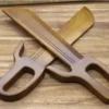 Two wooden butterfly swords displayed with blades crossed, on a wood bench surface.
