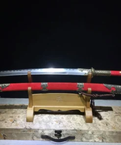 A two handed, Chinese curved sword and its decorative scabbard displayed on a small wooden stand.