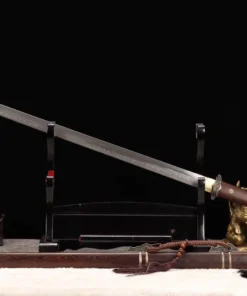 A straight, single edged Chinese sword leaning against a small stand, with its wooden scabbard below on the floor.