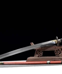 A Chinese saber sword displayed against a small wooden sword stand, with its decorative scabbard below on the floor.