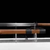 A Chinese broad shortsword and its wooden scabbard displayed on a stand.